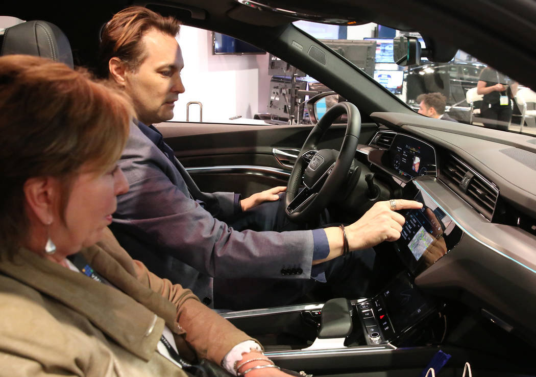 Showgoers check out digital dashboard display inside Audi e-tron during the National Associatio ...