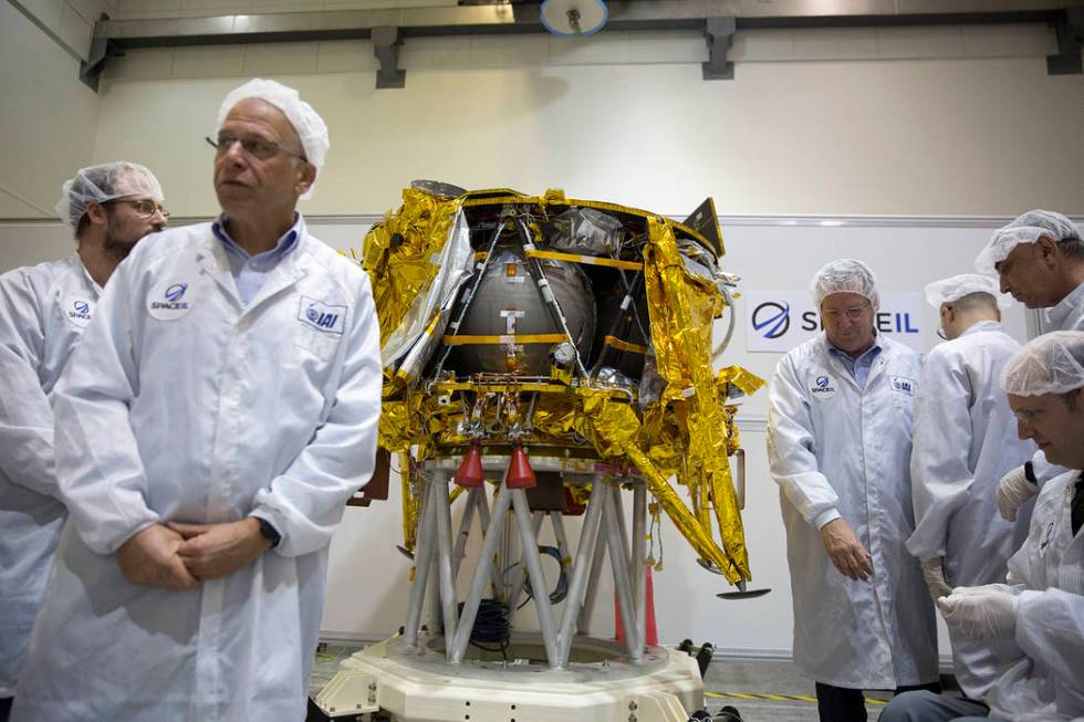 In this Monday, Dec. 17, 2018 file photo, technicians stand next to the SpaceIL lunar module, a ...