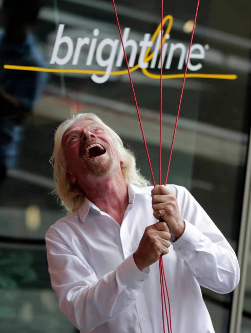 Richard Branson, of Virgin Group, prepares to unfurl a banner during a naming ceremony for the ...