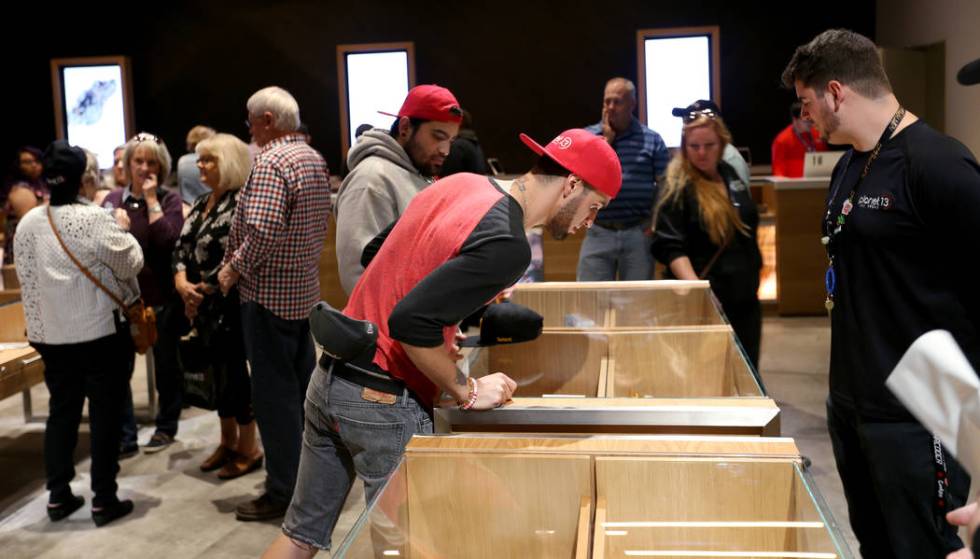 Daniel Diaz of Las Vegas checks out product with the help of budtender Zach Brengman at Planet ...