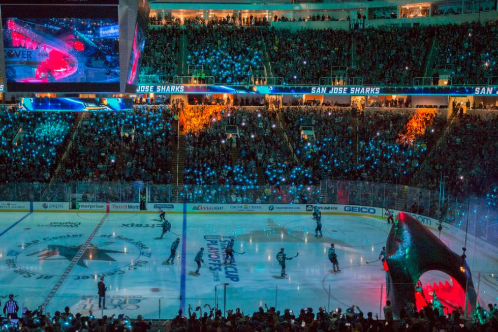 San Jose players circle the ice after entering through a massive shark head, right/bottom, at S ...