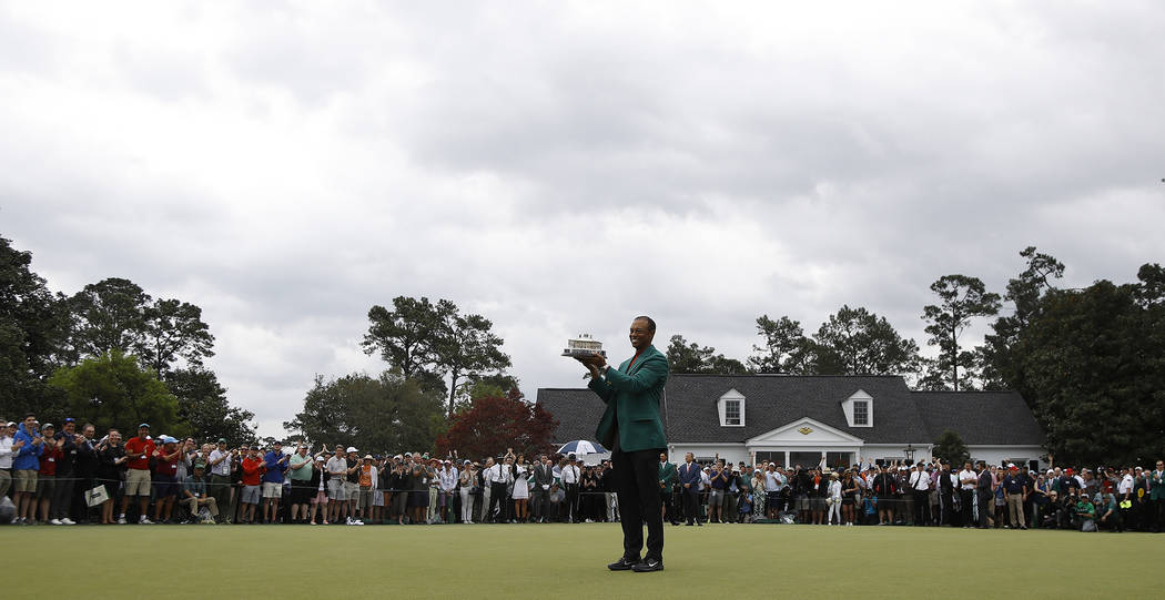 Tiger Woods holds his trophy after winning the Masters golf tournament Sunday, April 14, 2019, ...