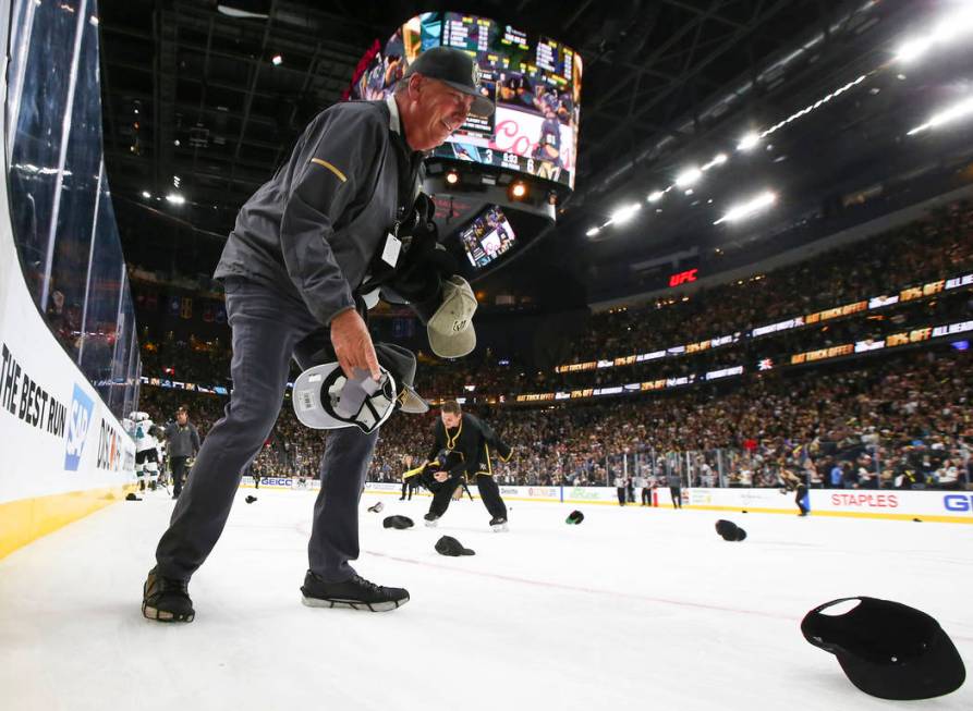 Members of the ice crew pickup hats thrown onto the ice as the Golden Knights celebrate a hat t ...