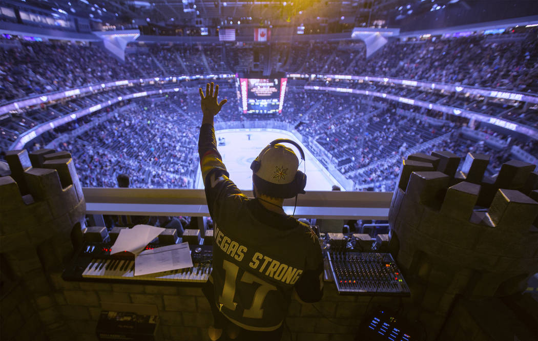 Golden Knights music director Jake Wagner waves to the crowd at the end of the first period dur ...