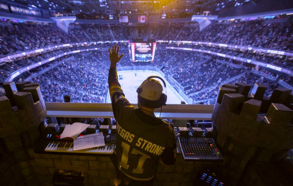 Golden Knights music director Jake Wagner waves to the crowd at the end of the first period dur ...