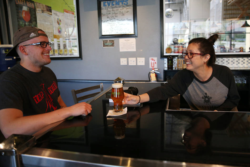 Beertender Chelsie Kesjaral, right, serves a beer for Max Lovelady, at CraftHaus Brewery in Hen ...