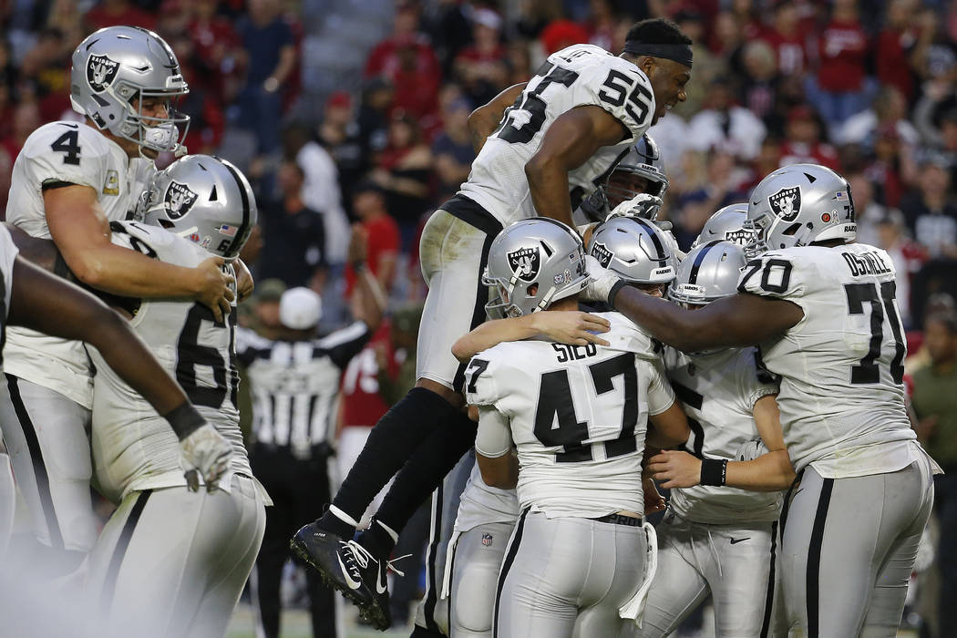 The Oakland Raiders celebrate as time expires during the second half of an NFL football game ag ...