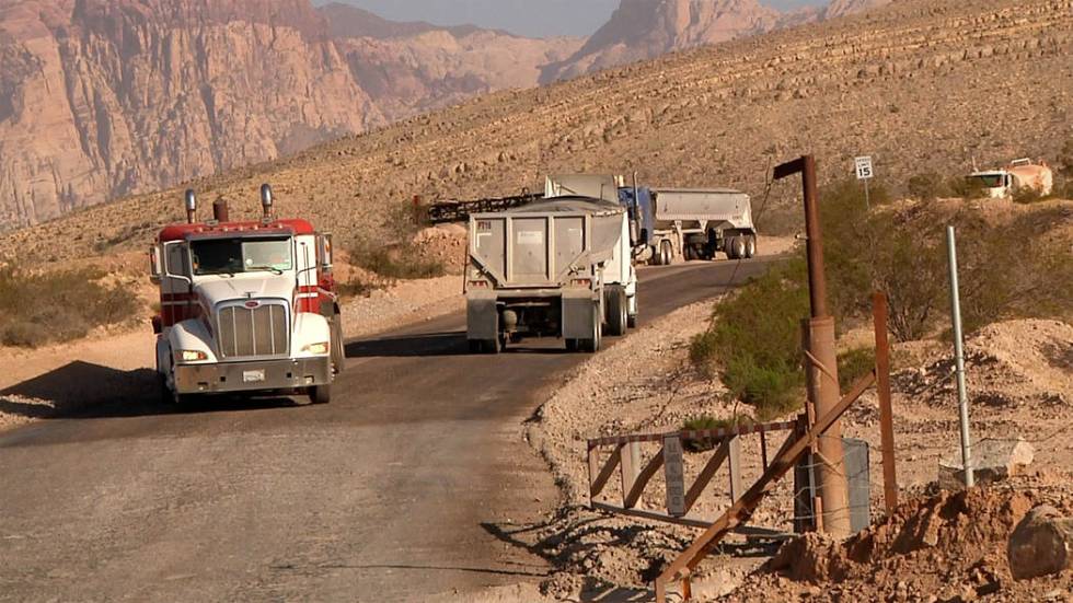 Trucks make their way up and down the road to Blue Diamond Hill Gypsum Mine where developers wa ...