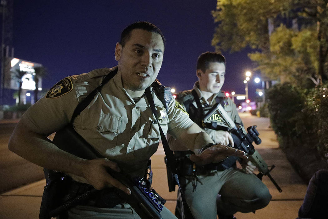 Police officers advise people to take cover near the scene Oct. 1, 2017, of a shooting near the ...