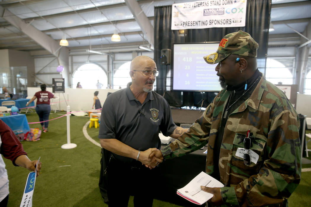 Ronald Gibson of Reliance Security, left, sets up a job interview with U.S. Marine veteran Alfr ...