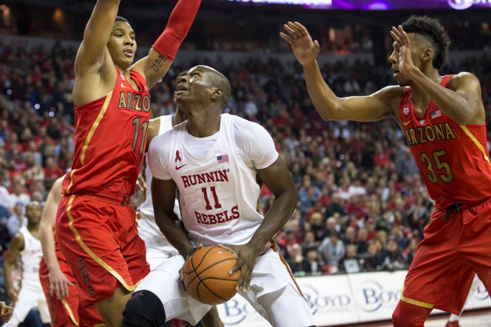 UNLV Rebels forward Cheickna Dembele (11) looks for a shot under pressure from Arizona Wildcats ...