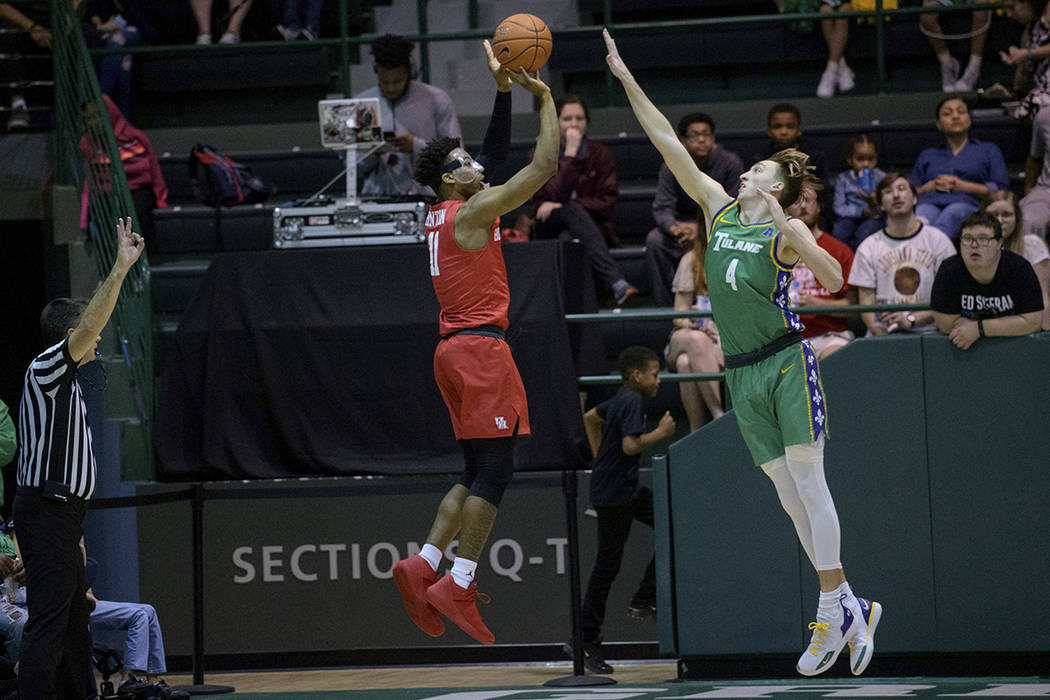 Houston guard Nate Hinton (11) shoots a three pointer against Tulane guard Moses Wood (4) in th ...