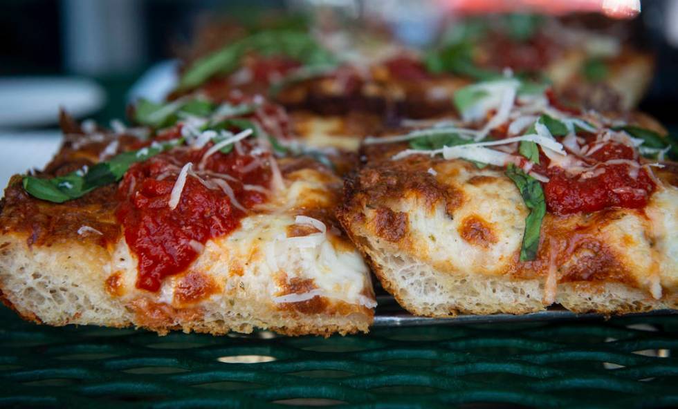 A slice of Detroit-style cheese pizza, left, sits next to a gluten-free slice of Detroit-style ...