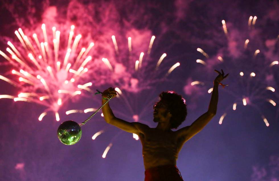 Deven Williams of the Kalliope dances on an art car as fireworks go off during the third day of ...