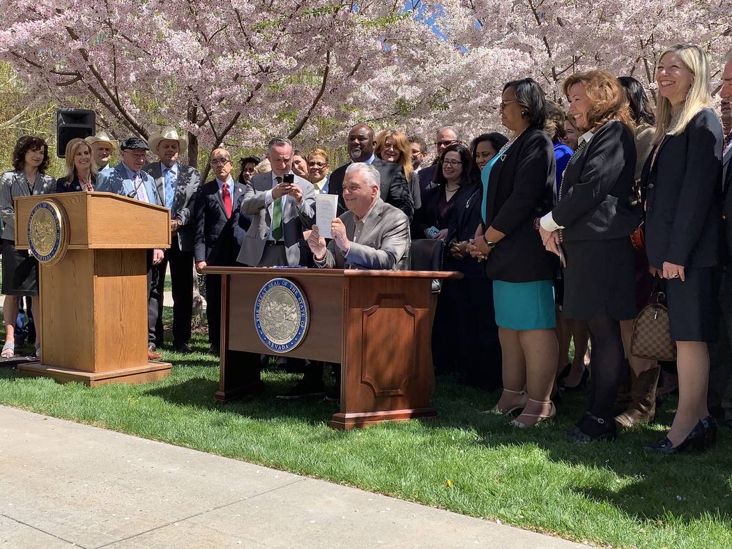 Nevada Gov. Steve Sisolak signs Senate bill 358, committing the state to run on at least 50 per ...