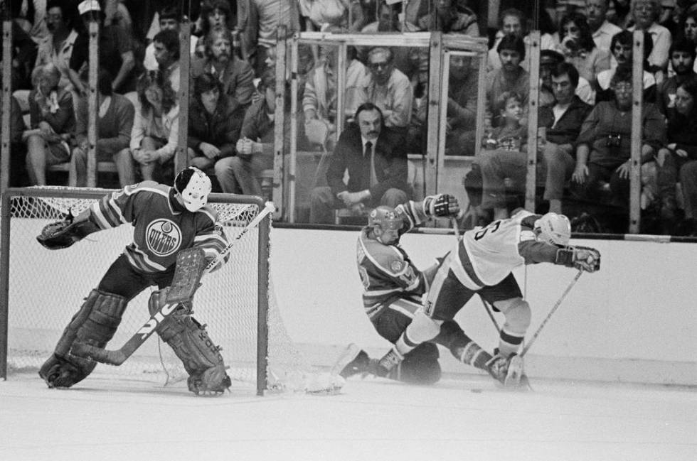 Edmonton Oilers' goal tender Grant Fuhr watches teammate Jari Kurri (17), center in dark unifor ...