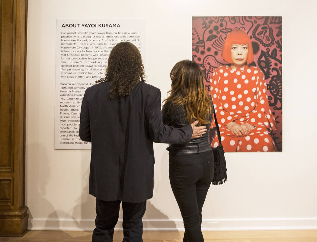 Matt Kelemen, left, and Gisela Lacayo read background information on artist Yayoi Kusama at her ...