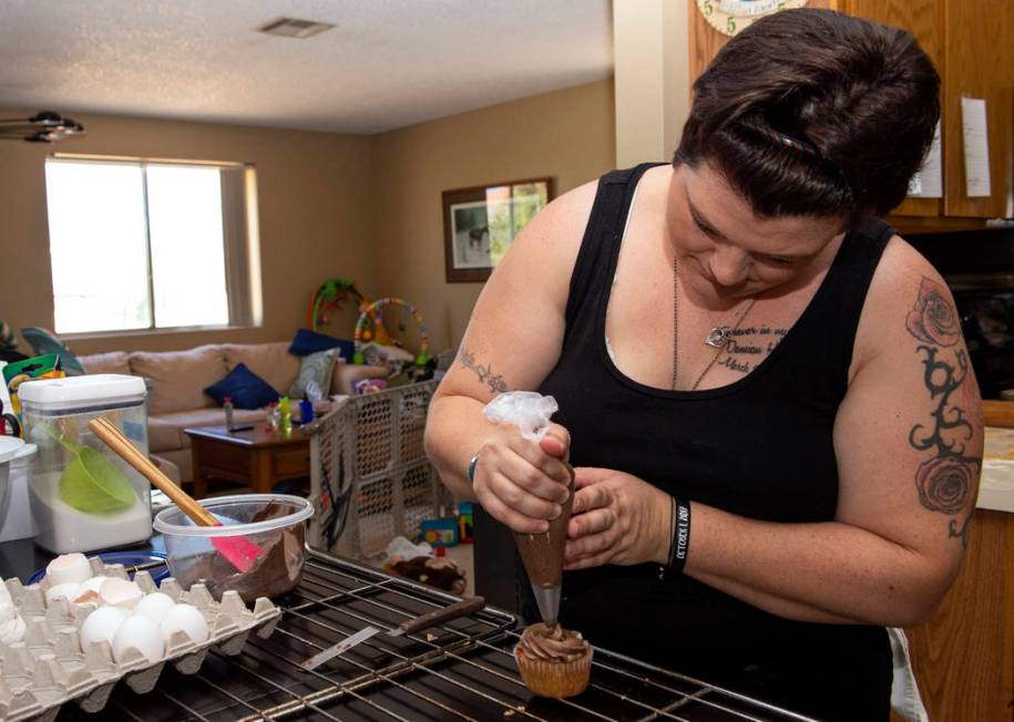 Owner of Cakes, Cookies and Creations Jessica Dejarnett tops a cupcake with chocolate buttercre ...