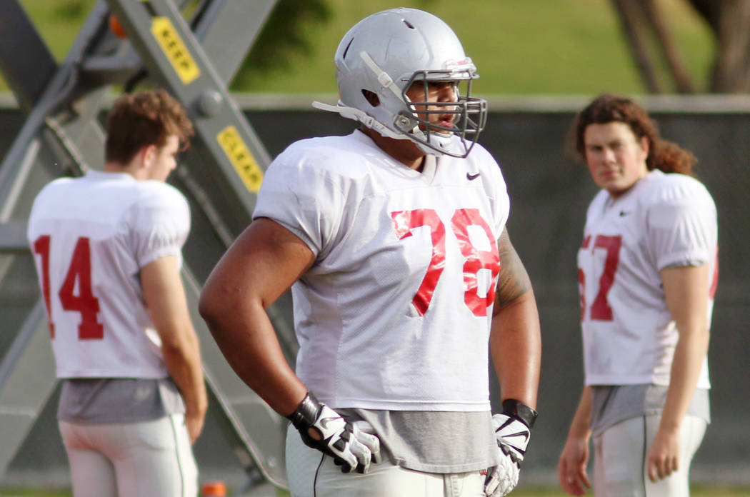 UNLV's Justin Polu, center, sits out on a drill rotation and watches teammates at UNLV football ...