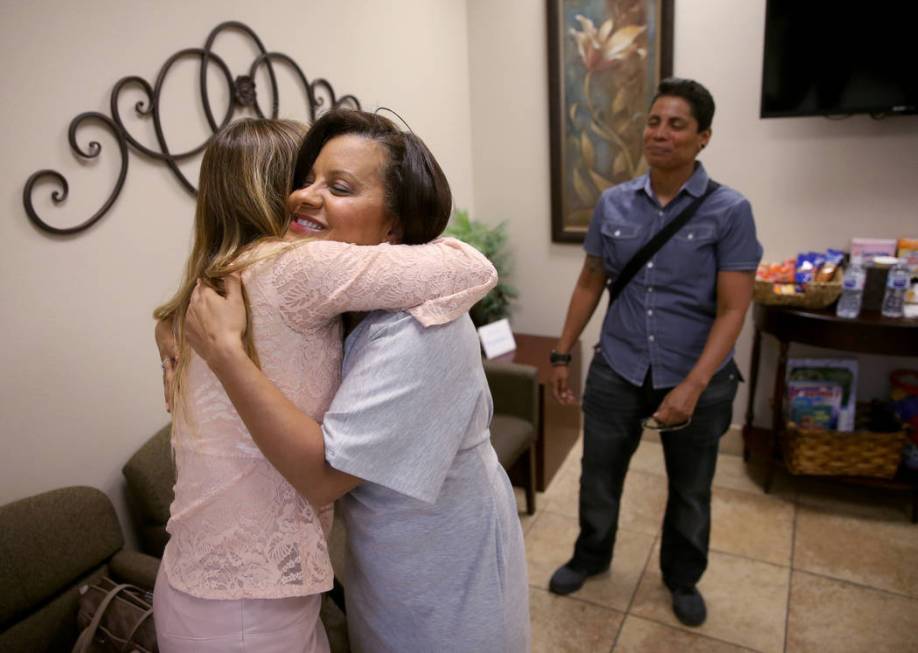 Ana Martinez, facing, a veteran who was homeless two years ago, hugs her loan officer, Jeny Ret ...