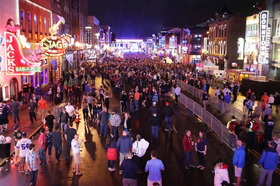 Fans line up Broadway in the rain to watch the first round of the NFL football draft in Nashvil ...