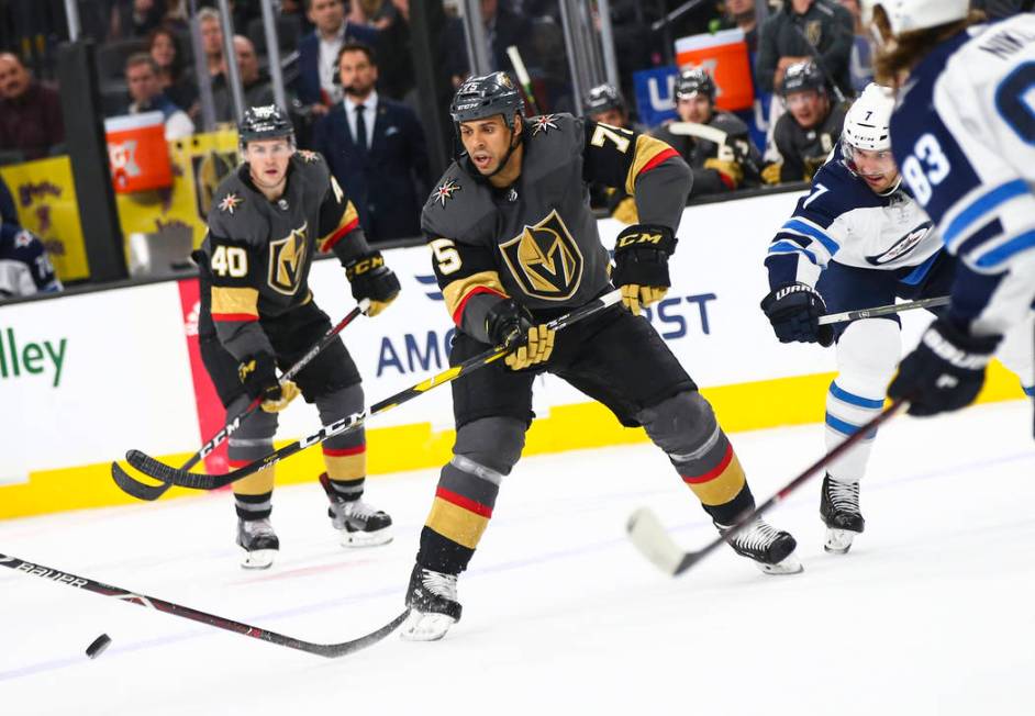 Golden Knights right wing Ryan Reaves (75) passes the puck under pressure from Winnipeg Jets de ...