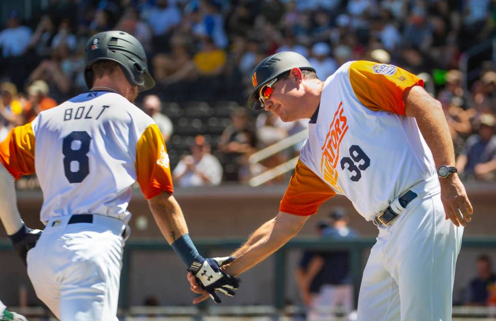 Base runner Skye Bolt (8) is congratulated on a score by Aviators manager Fran Riordan (39) as ...