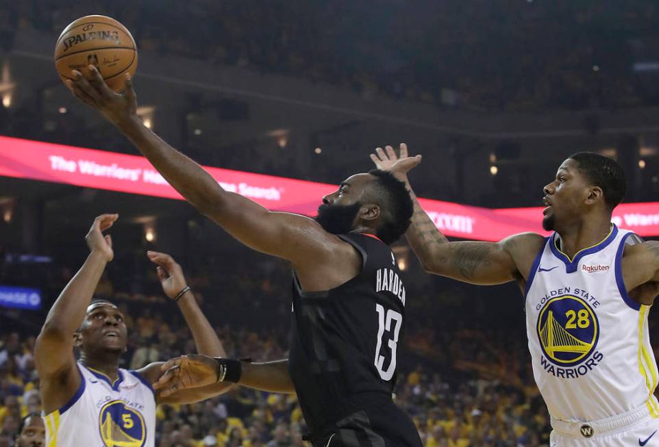 Houston Rockets guard James Harden (13) shoots between Golden State Warriors center Kevon Loone ...