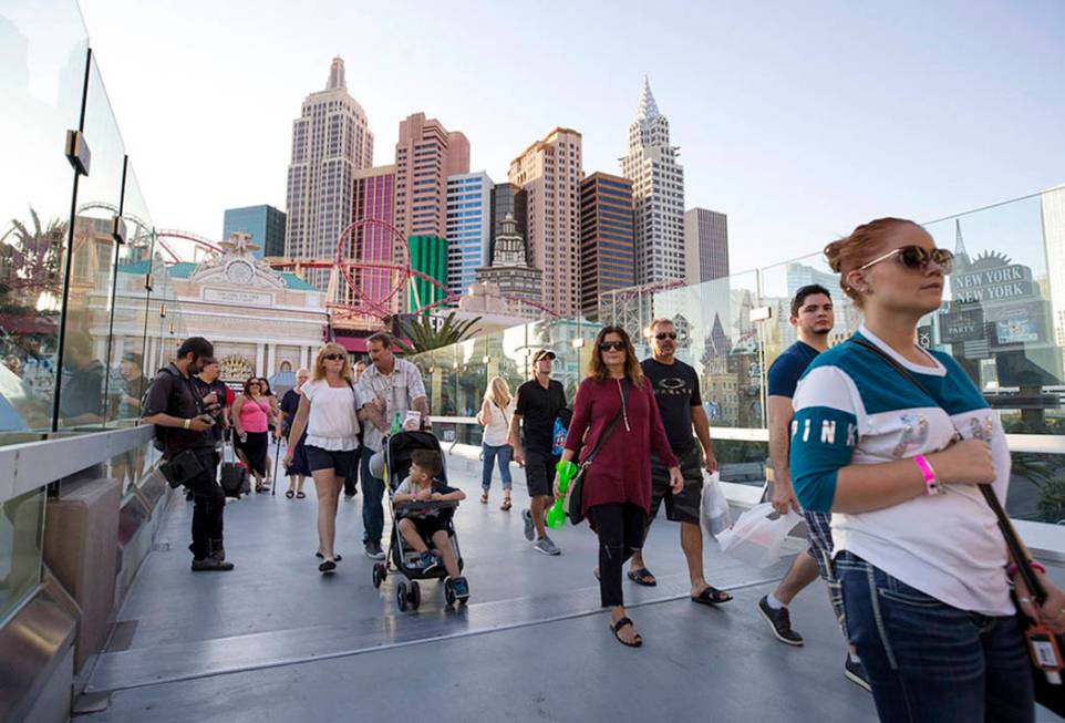 People walk over a pedestrian bridge linking New York-New York and MGM Grand near the intersect ...