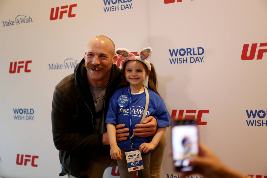 Judy Haynes, 4, poses with UFC fighter Pat Cummins after receiving her wish at an event by Make ...