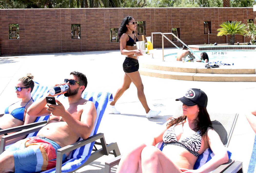 Ocie Hood, model cocktail server, delivers drinks to hotel guests at M Resort Spa Casino pool a ...