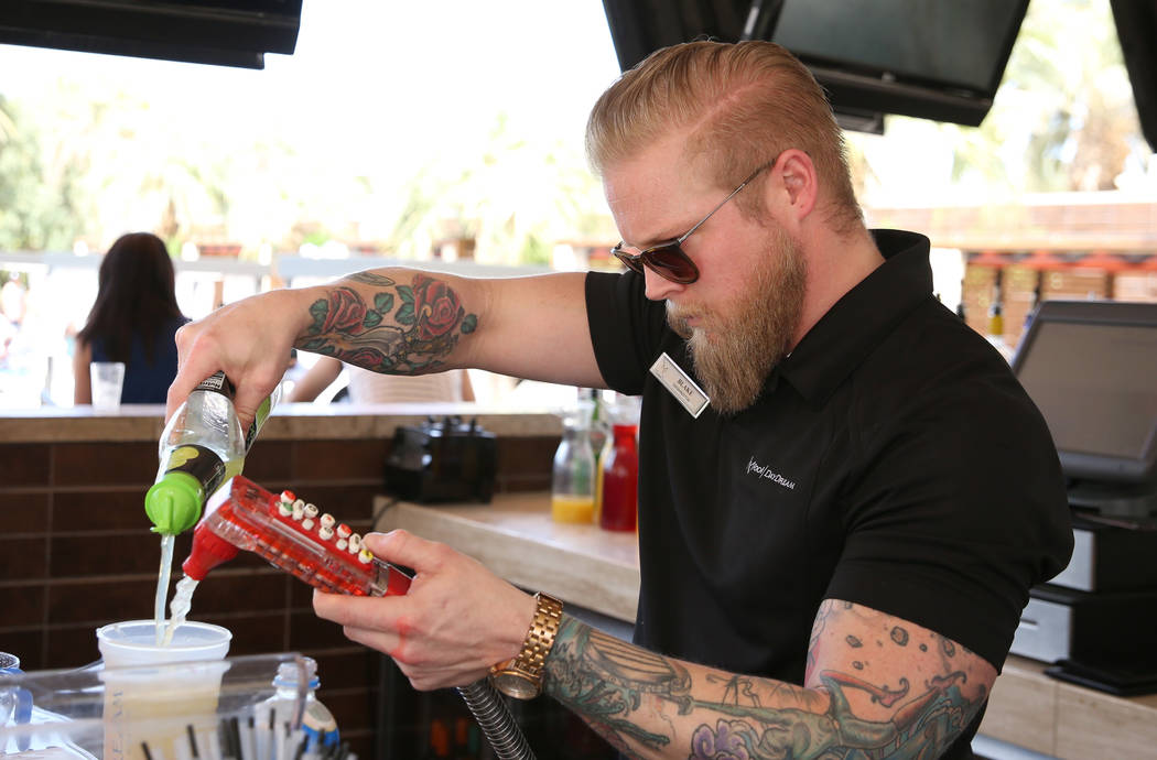Blake Brown, a bartender, mixes drinks at M Resort Spa Casino pool area on Saturday, April 27, ...