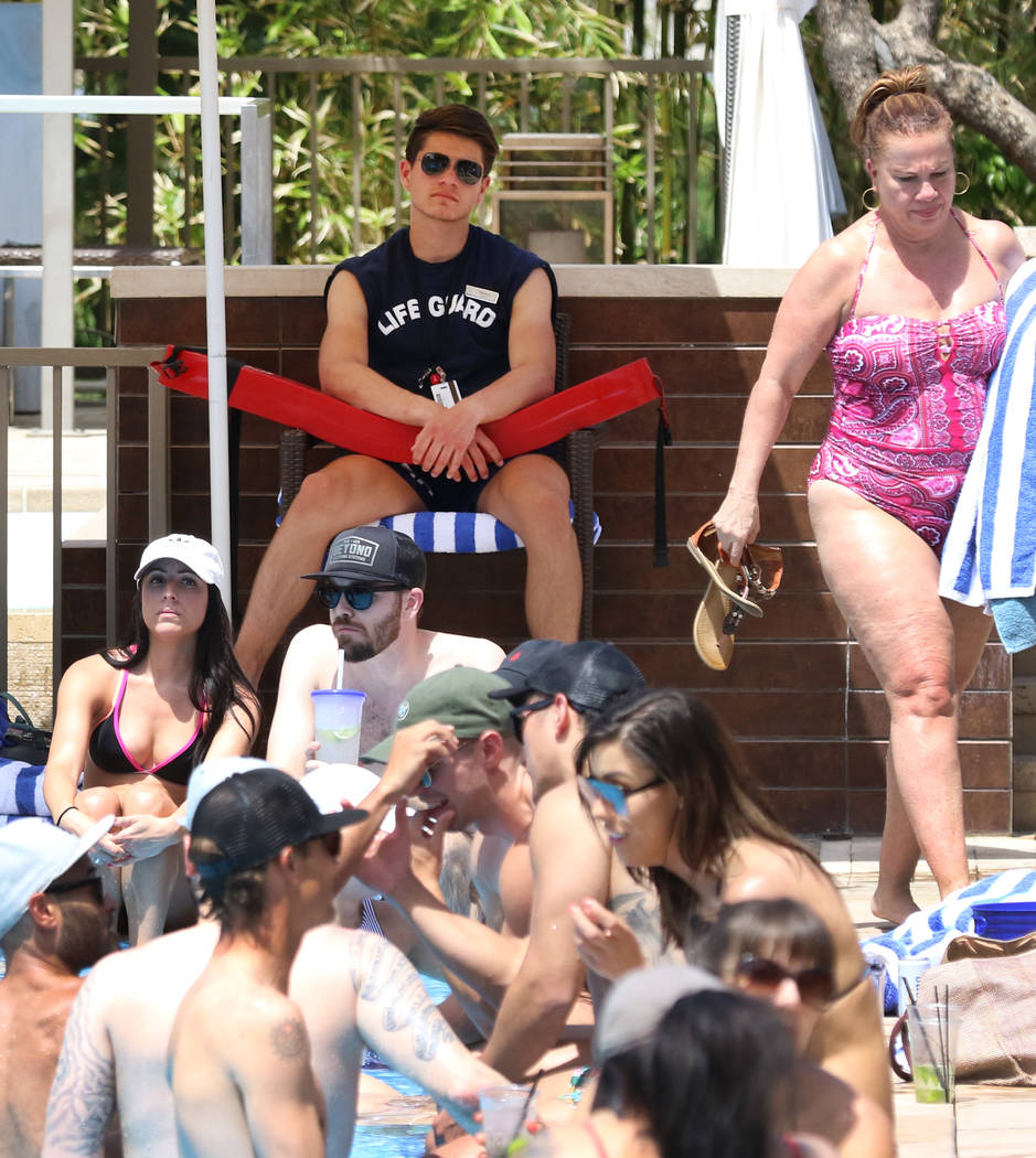 Life guard Thomas Flannery watches as hotel guests relax at M Resort Spa Casino pool on Saturda ...