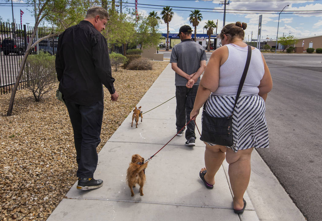 Ron Cochran, with his dog Cookie, visits with friends Christian Bridges and Rebecca Zima-Reinha ...