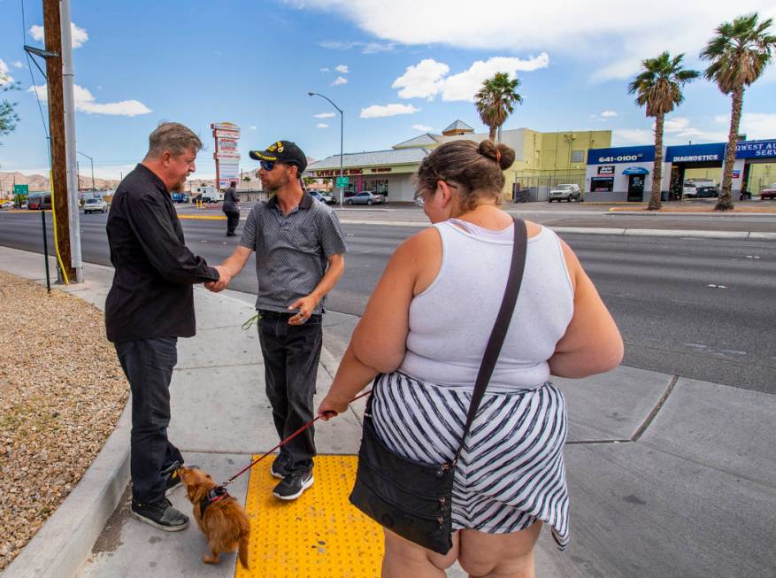 Ron Cochran, with his dog Cookie, says goodbye for the day with friends Christian Bridges and R ...