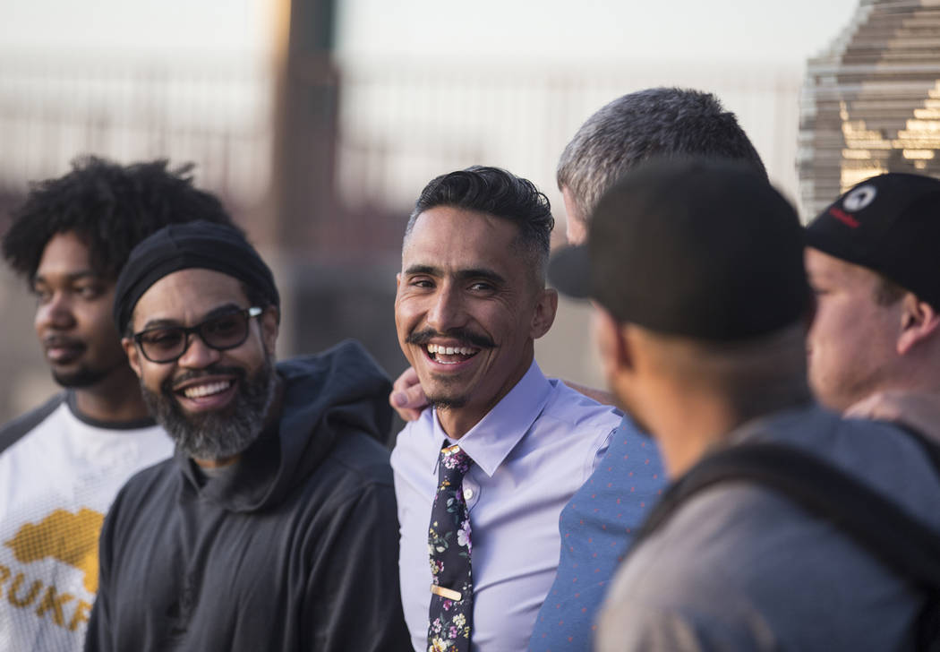 Artist Luis Varela-Rico, middle, jokes around with friends during a dedication ceremony for hi ...