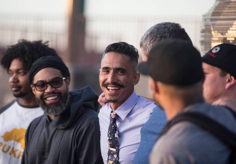 Artist Luis Varela-Rico, middle, jokes around with friends during a dedication ceremony for hi ...