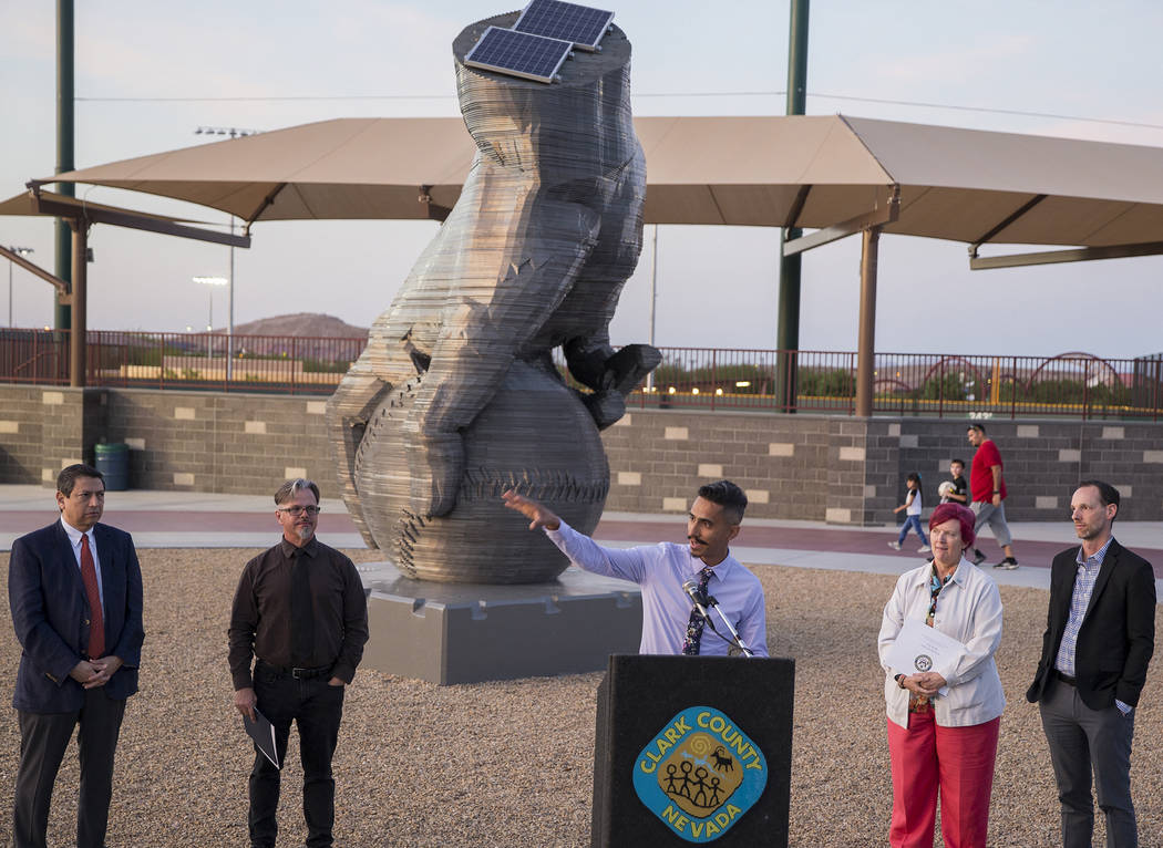 Artist Luis Varela-Rico, middle, speaks during a dedication ceremony for his sculpture "Or ...