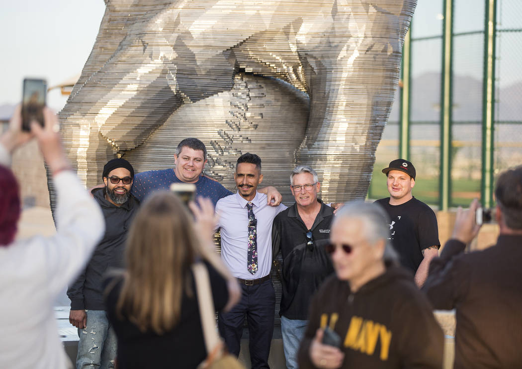 Artist Luis Varela-Rico, back/middle, takes photos in front of his sculpture "Organic Stud ...