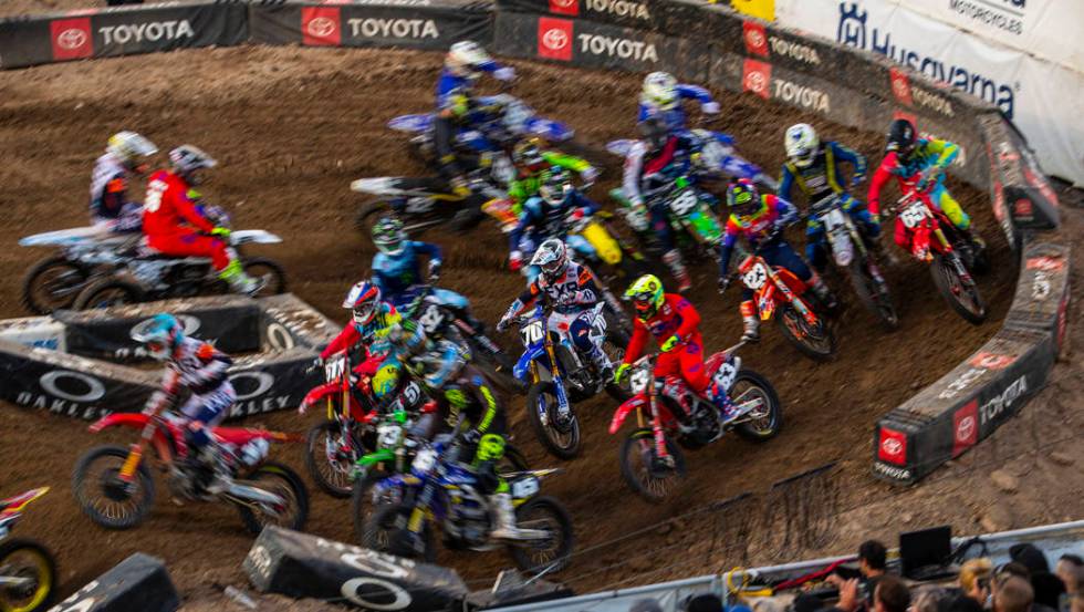 Riders blur through the fist main turn during the featured 250 SX class race at Sam Boyd Stadiu ...