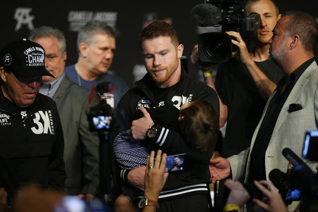 Saul "Canelo" Alvarez holds his daughter Emily as he speaks to reporters during a pre ...