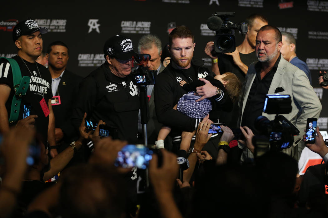 Saul "Canelo" Alvarez holds his daughter Emily as he speaks to reporters during a pre ...
