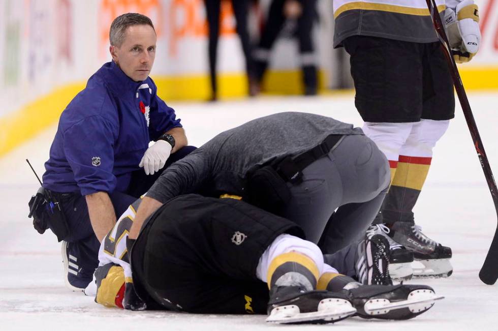 A trainer attends to Vegas Golden Knights center Erik Haula (56), who had taken a hit along the ...