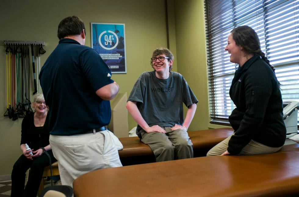 Grayson McClure, center, and his mother, Kay McClure, left, talk with physical therapists Walke ...