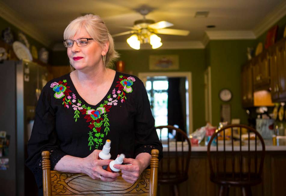 Kay McClure holds a pair of oral sprays used by her son, Grayson, at their home in Collierville ...