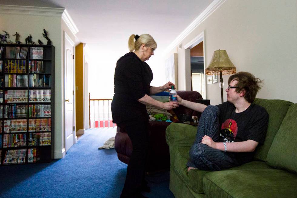 Kay McClure gives her son, Grayson McClure, morning medication at their home in Collierville, T ...