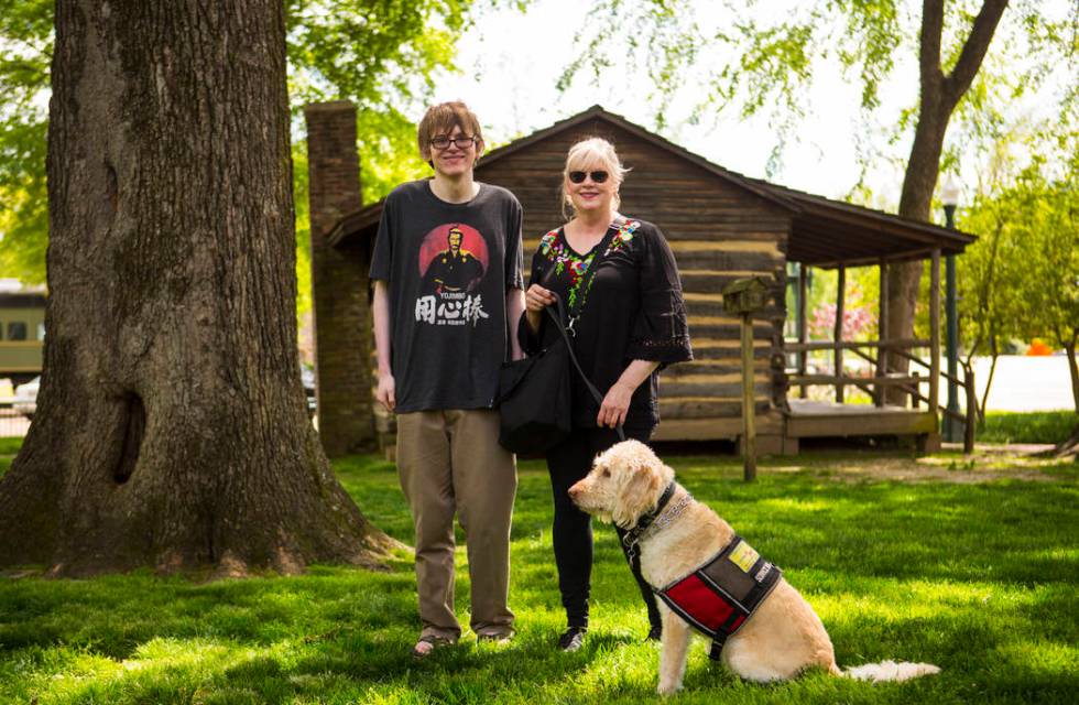 Grayson McClure, left, stands with his mom, Kay McClure, and service dog Yojimbo, at the park a ...