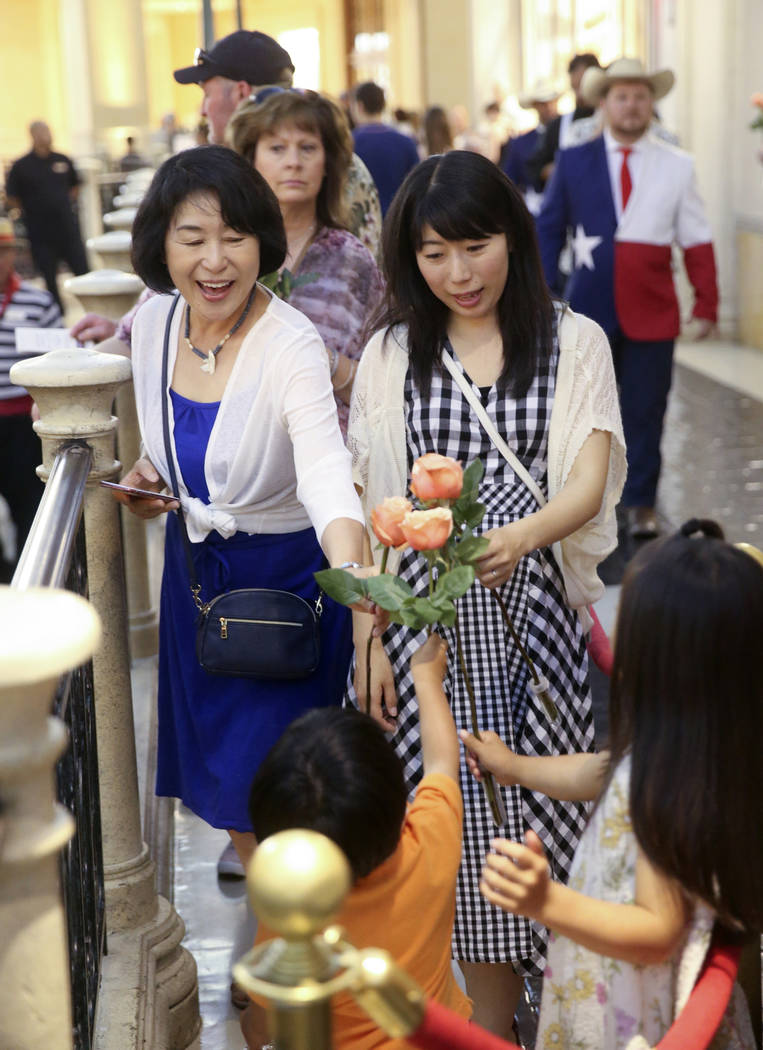 Reiko Yuasa, left, and Kanako Arai of Japan share their free roses with Arai's children Shotaro ...