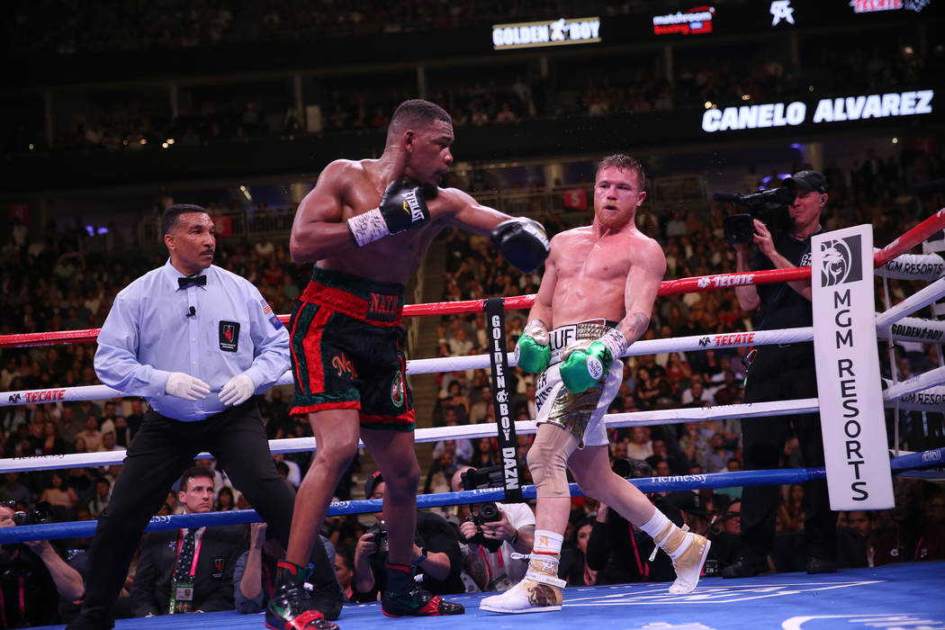 Saul “Canelo” Alvarez, right, moves away from a punch against Daniel Jacobs in th ...