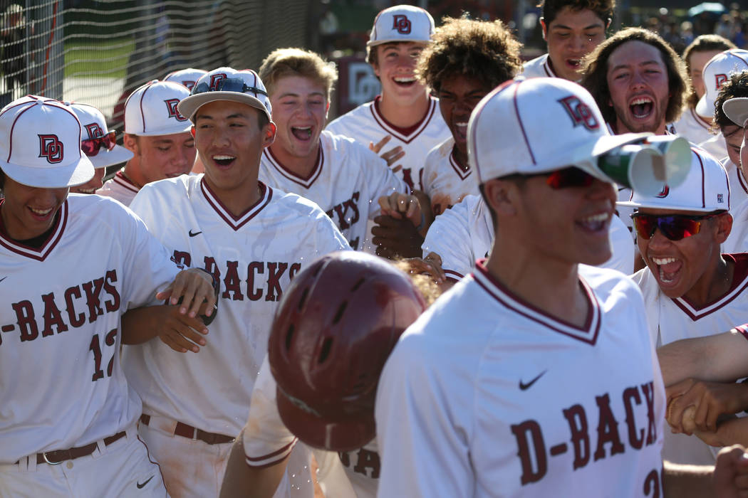 Desert Oasis celebrate a two run homer by Campbell Holt (16) against Basic in the Desert Region ...